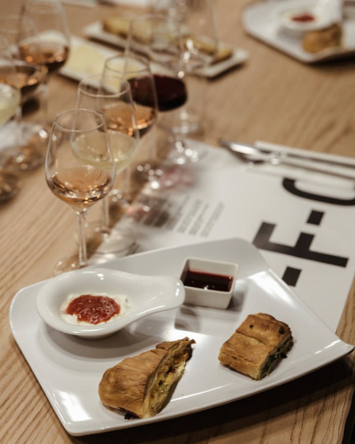 Glasses of wine and a plate of cheese and bread at a tasting table